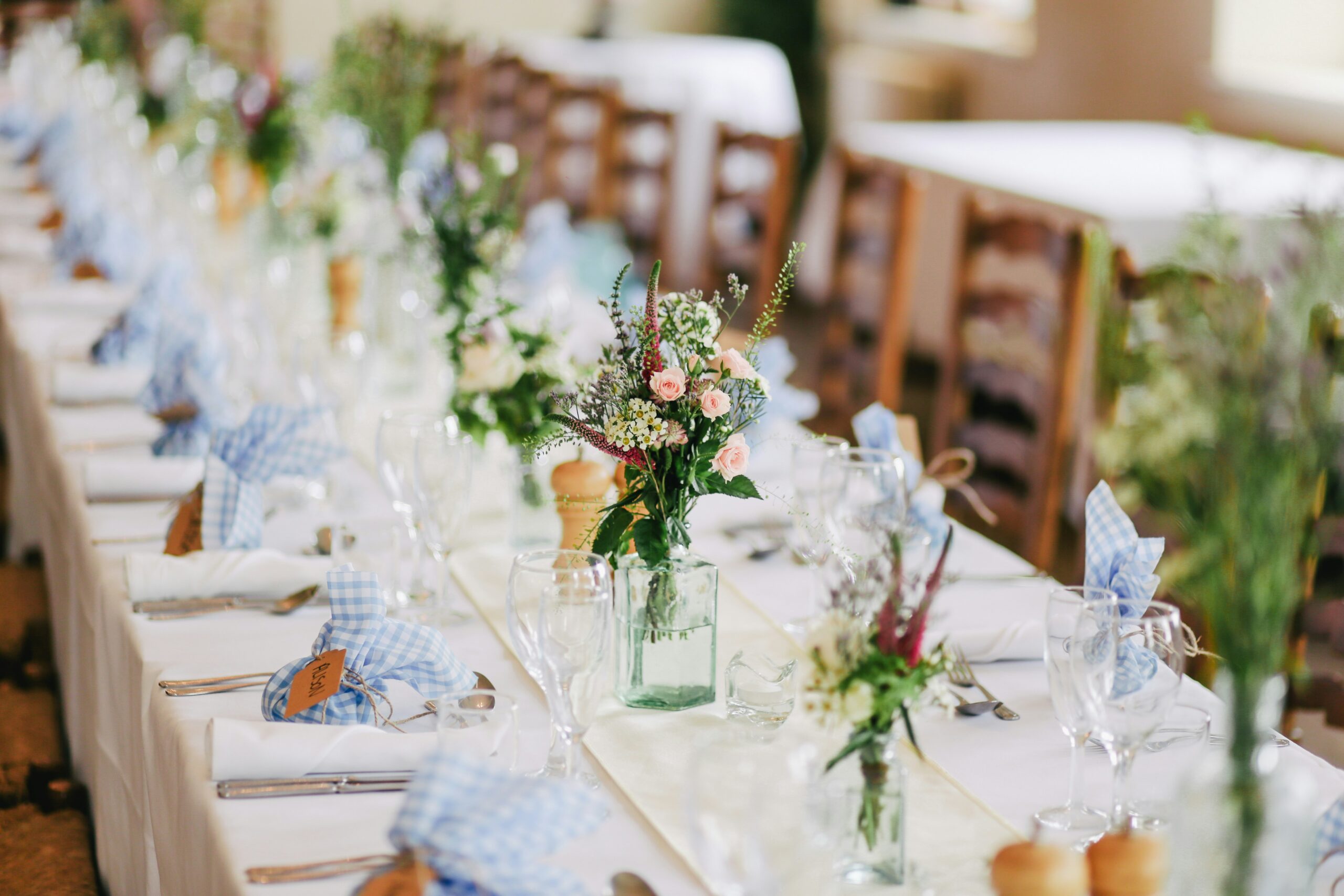 Elegant banquet table set with a tablecloth, glassware, and floral centerpieces